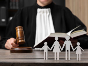 Family law. Judge with gavel and book sitting at wooden table,